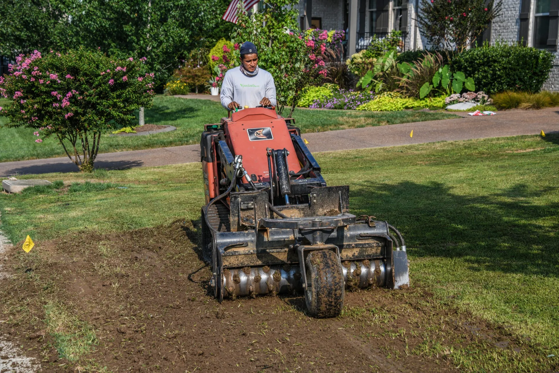 A crewman running a Harley rake before sod