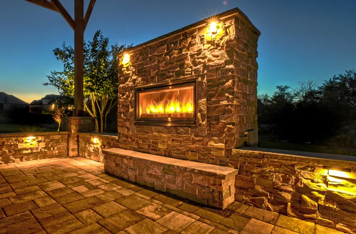A stone fireplace and seat wall at twilight