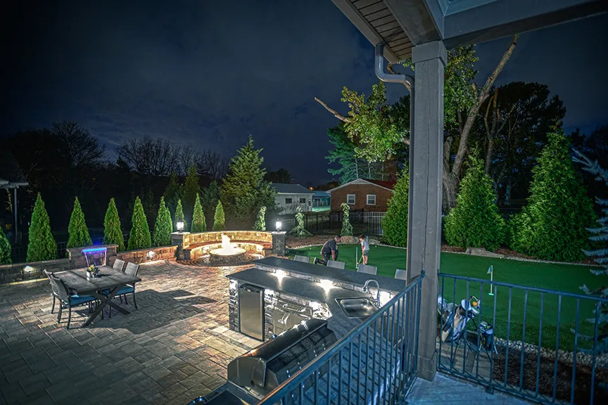 A patio with a fire table and lit seat walls