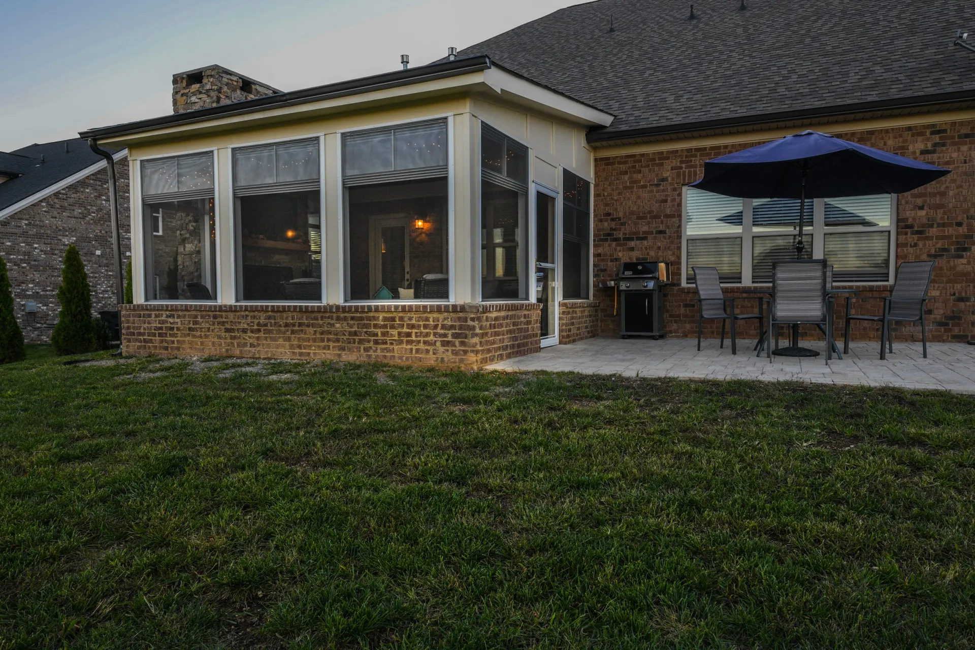 A screened porch and patio seen from the lawn