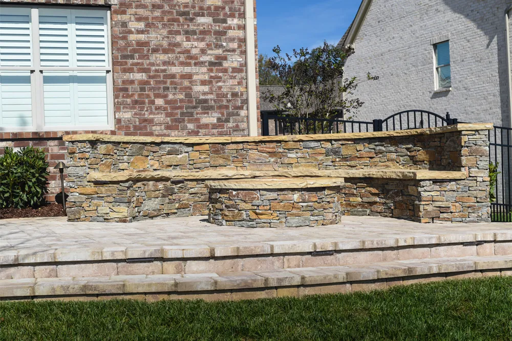 A stacked-stone seat wall against a brick home